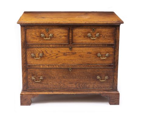 A 20TH CENTURY OAK CHEST OF TWO SHORT AND TWO LONG DRAWERS with brass swan neck handles and bracket feet, 95cm wide x 61cm de