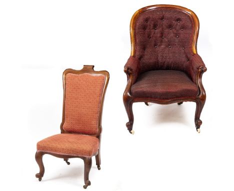 A VICTORIAN CARVED WALNUT FRAMED UPHOLSTERED ARMCHAIR with scrolling arms, cabriole legs and ceramic casters, 70cm wide x 66c