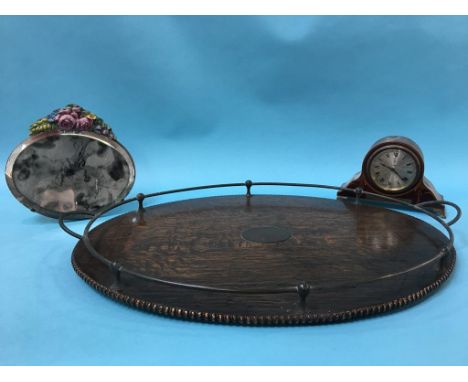 A 1920's oak oval tea tray, a barbola mirror and an Edwardian mantel clock (3)