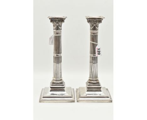 A PAIR OF PRESENTATION CANDLESTICKS, Corinthian columns, scrolling and swag detail beneath the drip pans, on stepped square b