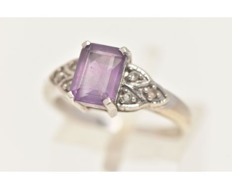 A 9CT WHITE GOLD GEM SET RING, set with a central rectangular cut amethyst, flanked with small circular cut colourless stones