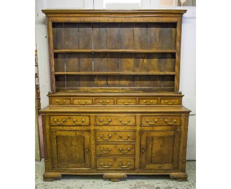 DRESSER, George III oak, ash and elm, circa 1780, with open plate rack above six spice drawers and base of six further drawer