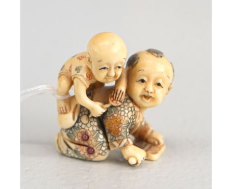 Netsuke, zwei spielende Kinder, China, um 1900Krabbelndes Kind mit Klatsche, auf dem Rücken ein Baby, bunt bemalte Kleidung, 
