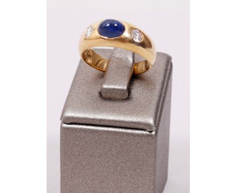 Ring 750er Gelbgold, zentraler blauer Saphir-Cabochon von ca. 1,20ct., 2 Brillanten von ca. 0,32ct., weiße Farbe / Reinheit V