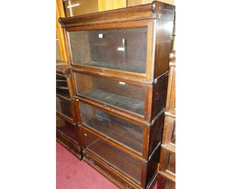 A 1920s oak Globe Wernicke four-tier stacking bookcase, having typical hinge glazed doors, with single long lower drawer, wid