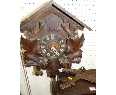 An early 20th century Swiss stained and carved walnut wall mounted cuckoo clock, with twin weights 
