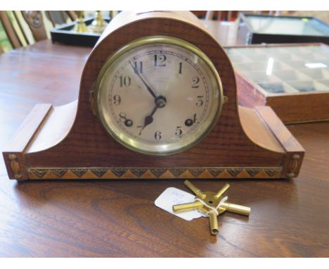 A 1920's oak cased mantel clock with brass winder