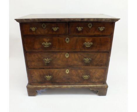 A George II walnut chest of two short and three long drawers with herringbone inlay and crossbanding, all raised on bracket s