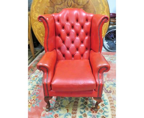 Leather upholstered Chesterfield wing back chair. Raised on short cabriole legs which have been thoughtfuly fitted with moder