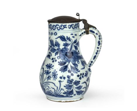 A 17th century Dutch Delft blue and white tankard decorated with a peacock and butterfly, circa 1660-1680, 16.5cm wide x 22cm