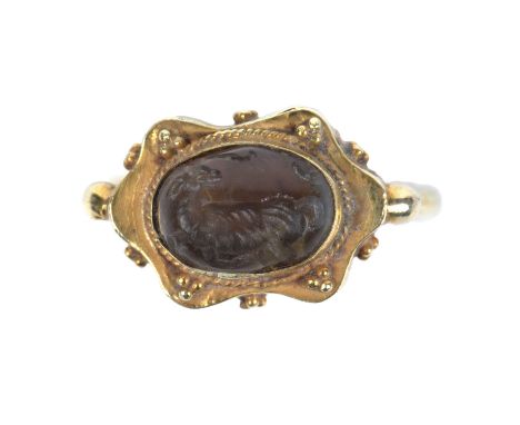 A Sasanian style rock crystal intaglio carved with an animal and mounted in a yellow metal ring, the stone 1cm x 1.3cm.
