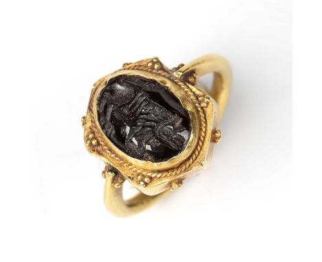 A Sasanian style intaglio carved with an animal and mounted in a yellow metal ring, the stone 1.5cm x 1cm.