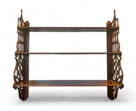 A Chippendale style mahogany three tier hanging shelf
With pierced Gothic arched sides, 92cm wide, 21cm deep, 92cm high.