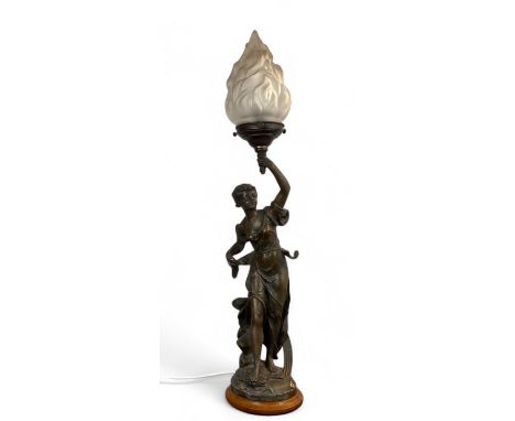An early 20th century French Art Nouveau spelter figural table lamp
Of a young woman holding aloft a glass shade torchere, on