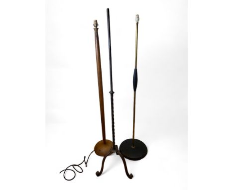 Three vintage standard lamps
Comprising of a wrought iron lamp, a teak and an ebonised and brass lamp, fitted for electricity