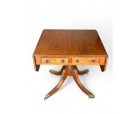 A Regency style mahogany sofa table
The hinged rectangular top above a pair of frieze drawers and opposing dummy drawers, on 