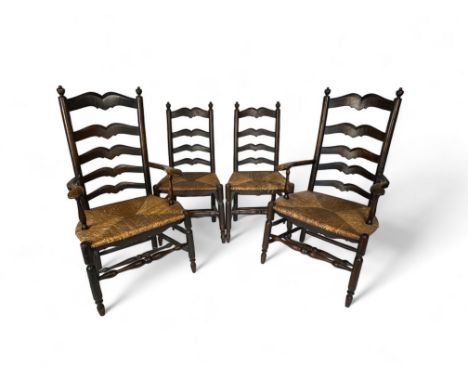 A set of four early 20th century continental oak ladderback dining chairs including a pair of open armchairs
The turned finia