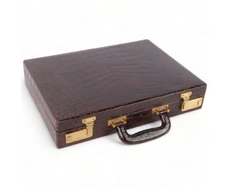 A Vintage amuet crocodile skin briefcase, with fitted interior, blotter, and brass locks, 41cm across 