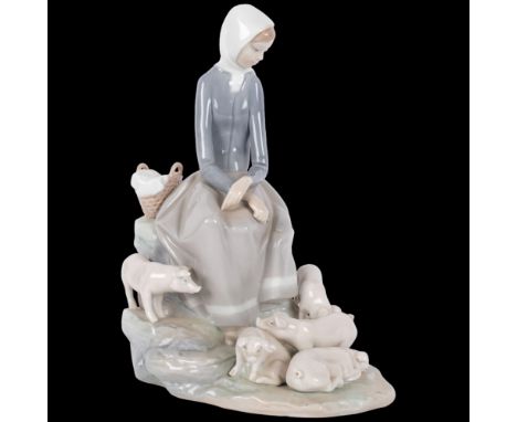 A Lladro porcelain figurine of a young woman seated, surrounded by 5 piglets, marked to the underside, with reference that ap