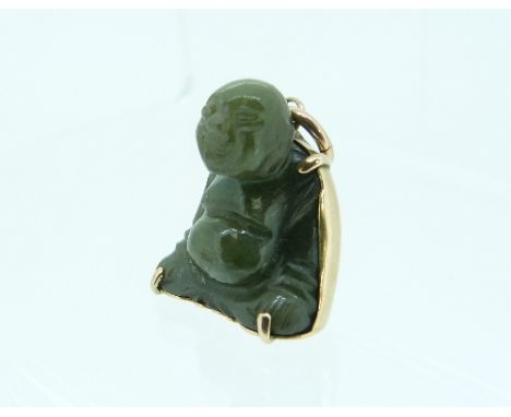 A jade Charm, in the form of a sitting Budda, his back covered in yellow metal with Chinese symbols and suspension loop, 1in 