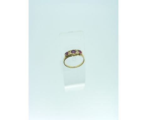 A five stone Ring set with three graduated pale rubies and three diamond chips all mounted in yellow metal. Size L½