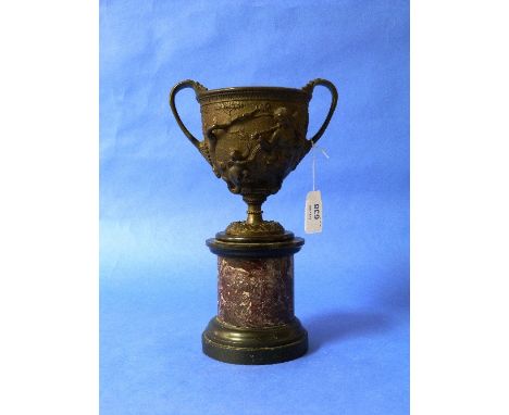 An early 20thC bronze Urn, of two-handled form with liner, relief-decorated with classical scenes, on a marbled cylindrical p