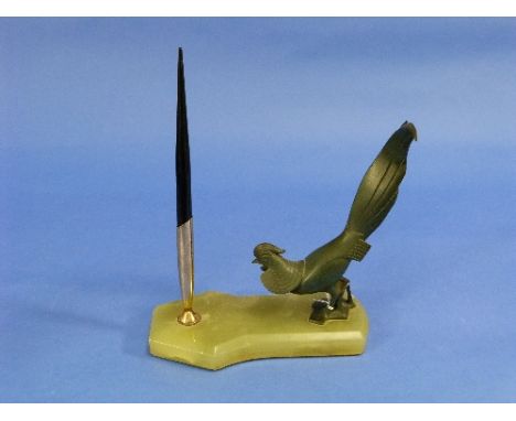 An Art Deco green marble Pen Stand, of shaped rectangular form, surmounted by a stylised bronze Cockerel, 7in (17.75cm) wide.
