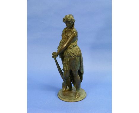A patinated bronze figure of a Classical Lady, she standing and leaning on a farm tool, 14½in (37cm) high.