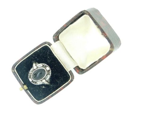 A Georg Jensen Ring, mounted in silver, the centre set with oval cabochon onyx, with a rope twist border applied with leaves 