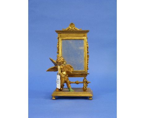 An early 20thC French gilt bronze group of a winged putto artist standing before a mirror, on rectangular base and bun feet, 