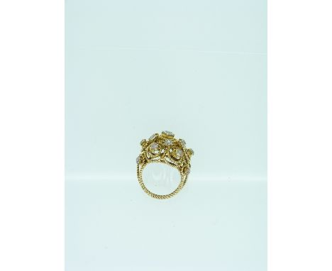 A yellow metal Ring, formed of three strands of ropework, the front with various open swirls of ropework set with a central d