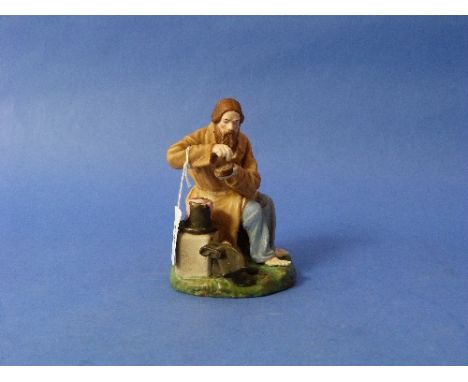A 19thC Russian 'Gardner' painted bisque porcelain figure of a Peasant Salting Bread, seated, his hat and boots by his side, 