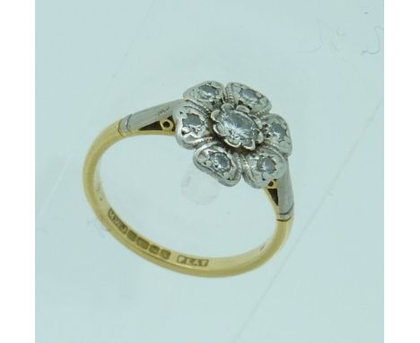 A Ring, the front set with a diamond surrounded by six petals each set with small diamond, mounted in 18ct yellow gold and pl