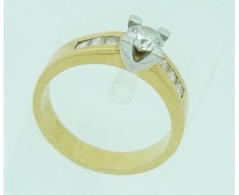 A modern 18ct yellow gold Ring, the front with two white gold V's, holding a single stone brilliant cut diamond, c½ct, each s