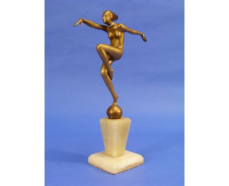 An Art Deco gilt spelter figure of a nude Dancer, on globe and set on a polished stone plinth, 12¼in (32cm) high.