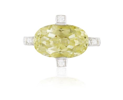 AN YELLOW BERYL AND DIAMOND DRESS RING, BY CHATILAThe central mixed-cut oval-shaped yellow beryl heliodor within a brilliant-