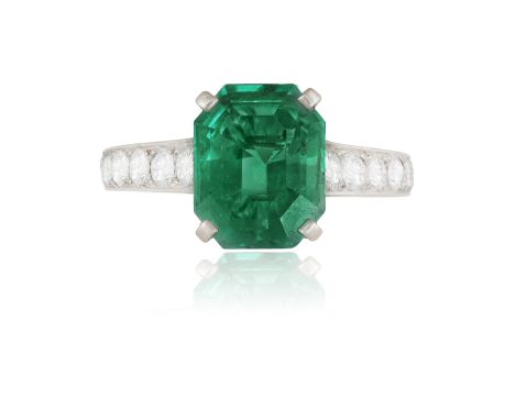 A RARE AND FINE EMERALD AND DIAMOND RING, BY CARTIERThe octagonal step-cut emerald weighing 3.39cts within a four-claw settin