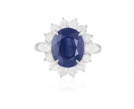 A SAPPHIRE AND DIAMOND CLUSTER RINGThe oval-shaped sapphire weighing approximately 5.80cts within a surround of brilliant-cut