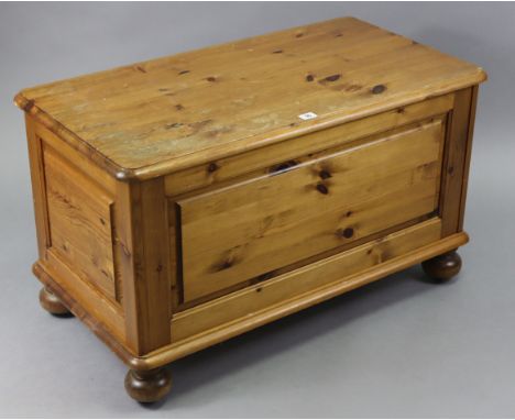 A pine blanket box with hinged lift-lid, fielded panel sides &amp; on bun feet, 34” wide x 20” high.