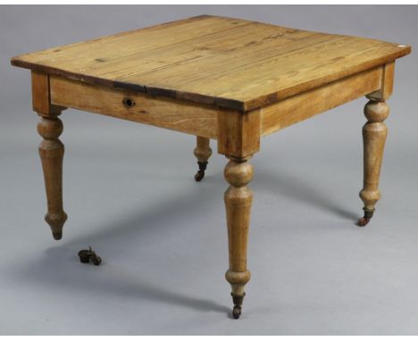 A pine kitchen table with rectangular top, &amp; on four turned legs with ceramic castors, 43” wide x 28½” high x 38” deep.