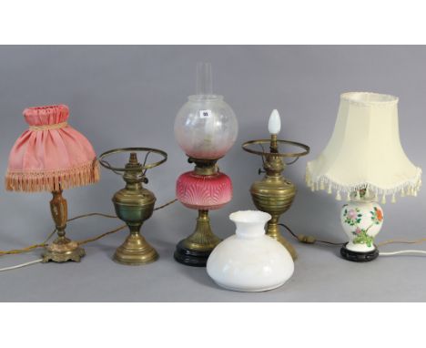 An Edwardian brass oil table lamp (converted to electricity) with crimson glass reservoir, &amp; with etched globular shade, 