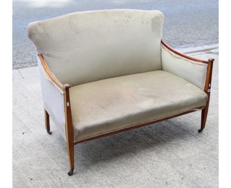 An Edwardian show wood-frame two-seater settee with padded seat, back &amp; arms upholstered fawn velour, &amp; on short squa