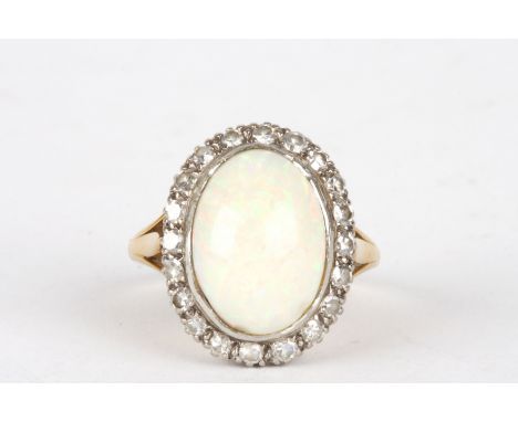 An 18ct gold, diamond and opal ring
the large oval opal surrounded by small diamonds and set in an platinum and gold mount.Di