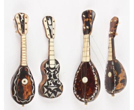 Three 19th century miniature tortoiseshell mandolins and a guitar
with ivory, bone and and another of pearl inlay.Dimensions: