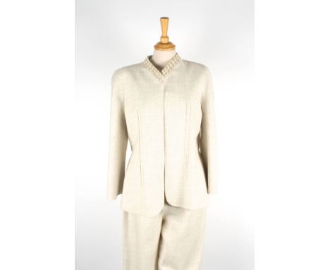 A Valentino trouser suit.
light beige suit with open fronted jacket trimmed with beading to collar and short beaded belt to b