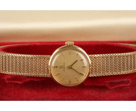 A 9ct gold ladies Omega wrist watch
the gilt dial with baton numerals, and a woven gold strap, in an Omega box.Dimensions: 24