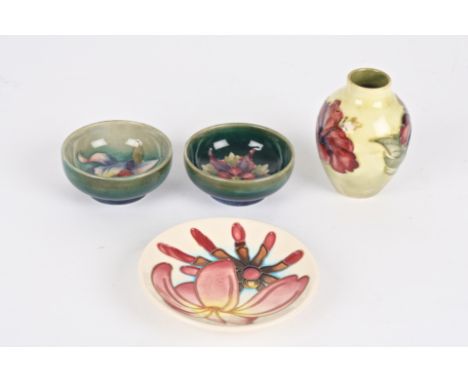 Four pieces of miniature Moorcroft
comprising a Hibiscus vase; a pair of small green ground floral bowls; and a modern floral