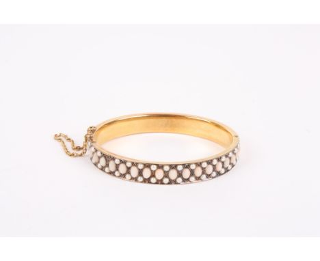 A Victorian seed pearl stiff bangle set with rows of seed pearls in an unmarked yellow metal frame, probably gold.Dimensions: