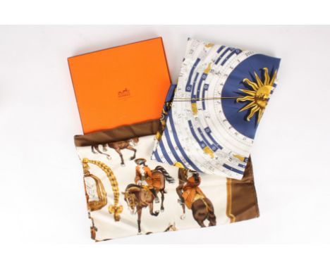 Two Hermès scarves, one in original box
the first predominantly navy and gold depicting signs of the zodiac, the second predo