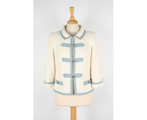 A Chanel cream boucle jacket.
with light blue trim, gold coloured Chanel buttons, two faux pockets with logo buttons, Europea